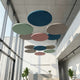 Circular ceiling rafts in a modern office setting with large windows.
