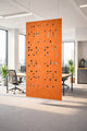 Orange decorative screen in an office setting with desks and chairs.