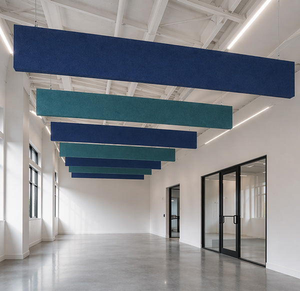 Blue and Dragonfly acoustic panels hanging from a ceiling in a modern room.