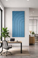 Modern office interior with a desk, chair, and abstract arch artwork on the wall.